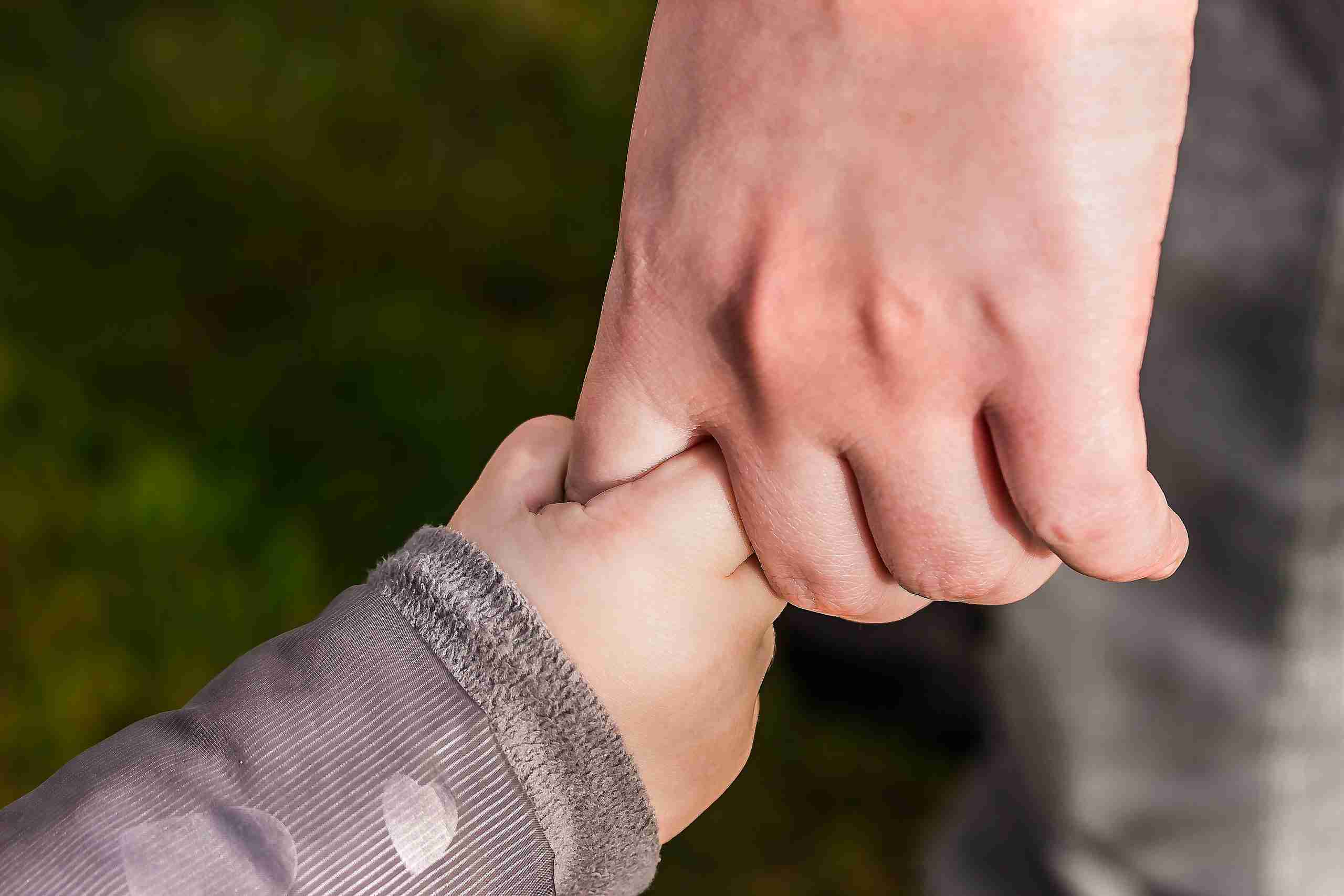 Child hand holding his father